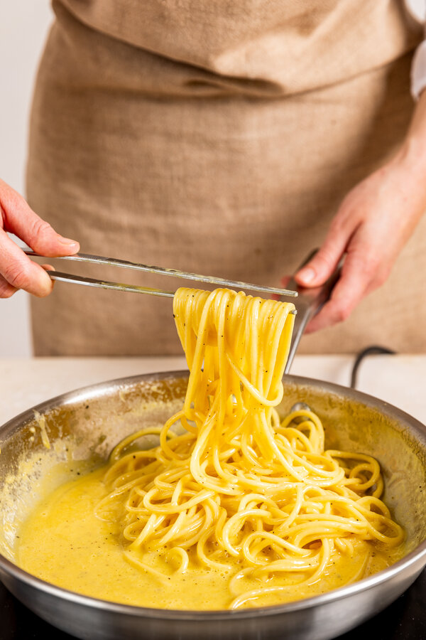Echa la pasta en la salsa carbonara